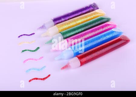 Colla colorata glitter isolata su bianco Foto Stock