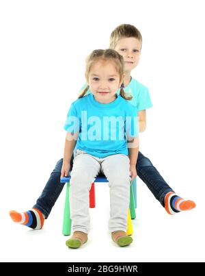 Bambini piccoli che giocano su sedie isolate su bianco Foto Stock