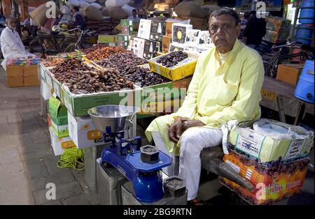 DELHI, INDIA - 12 MARZO 2019: Venditore che vende frutta secca ad un mercato della spezia nella vecchia delhi, india Foto Stock