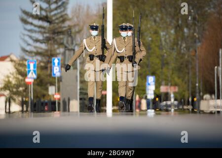 Varsavia, Polonia. 20 aprile 2020. I soldati che indossano maschere facciali effettuano un cambio di turno alla Tomba del Milite Ignoto di Varsavia, Polonia, il 20 aprile 2020. Il governo polacco ha attenuato alcune restrizioni associate alla pandemia COVID-19 di lunedì, riaprendo le foreste e i parchi al pubblico e consentendo ai negozi di ricevere più clienti nei loro locali. Credit: Jaap Arriens/Xinhua/Alamy Live News Foto Stock