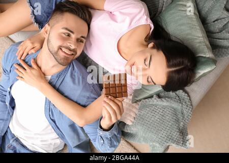 Bella giovane coppia mangiare cioccolato a casa Foto Stock