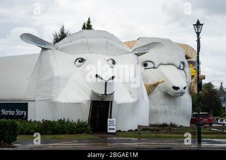 Big Dog e pecore edifici in ferro ondulato che ospitano il Centro visitatori e Negozio di lana, Tirau, Isola del Nord, Nuova Zelanda Foto Stock