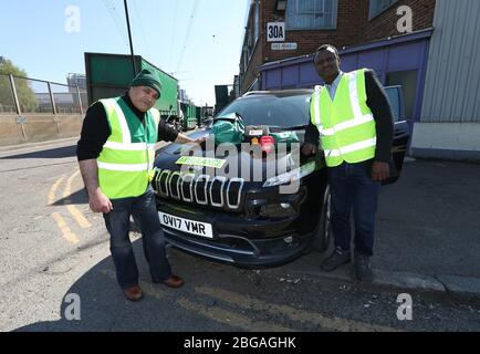 Jonathan Ganesh, presidente della Docklands Pappellers' Association (DVA) e un NHS Volontario Responder (a sinistra) e Ousman Marong, con un'ambulanza donata da Elite Support Services per sostenere gli sforzi contro l'epidemia di Covid-19, a Londra. Il signor Ganesh, vittima dei bombardamenti IRA del 1996 che hanno devastato i docklands di Londra, e i membri del DVA si sono registrati con il programma di volontariato Your NHS Needs You per alleviare la pressione sul servizio sanitario fornendo forniture essenziali a coloro che sono autoisolanti. Foto Stock