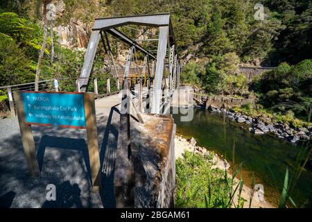 Ponte ferroviario sul fiume Ohinemuri vicino all'ingresso al tunnel ferroviario di Karangahake sul percorso ferroviario di Hauraki, Isola del Nord, Nuova Zelanda Foto Stock