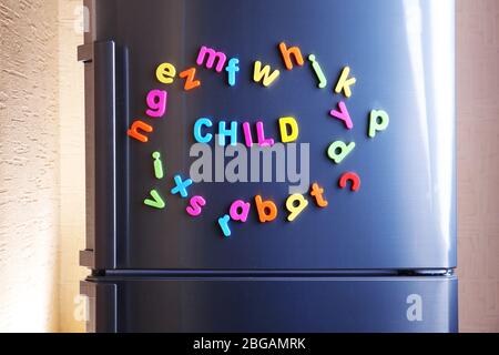 Parola Bambino scritto fuori usando le lettere magnetiche colorate sul frigorifero Foto Stock