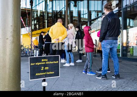 Berlino, Germania. 20 aprile 2020. La gente si accoda per entrare in un negozio di biciclette a Berlino, capitale della Germania, 20 aprile 2020. A partire da lunedì, i negozi in Germania con un'area di vendita massima di 800 metri quadrati possono aprirsi in base a nuove normative in materia di igiene, nonché di controllo dell'accesso e della coda. Credit: Binh Truong/Xinhua/Alamy Live News Foto Stock