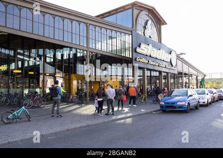 Berlino, Germania. 20 aprile 2020. La gente si accoda per entrare in un negozio di biciclette a Berlino, capitale della Germania, 20 aprile 2020. A partire da lunedì, i negozi in Germania con un'area di vendita massima di 800 metri quadrati possono aprirsi in base a nuove normative in materia di igiene, nonché di controllo dell'accesso e della coda. Credit: Binh Truong/Xinhua/Alamy Live News Foto Stock