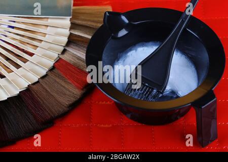 Composizione con campioni di capelli di colori diversi, pennello e colore su sfondo da tavolo Foto Stock