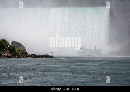 Cascate del Niagara, NY, USA - 13 giugno 2019: Tour in barca sotto la nebbia sotto le cascate Horseshoe sul fiume Niagara Foto Stock