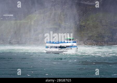 Cascate del Niagara, NY, USA - 13 giugno 2019: Nave con turisti si sposta alle cascate del Niagara, l'esperienza del tour in barca delle cascate è l'attrazione più antica del Nord America, e. Foto Stock