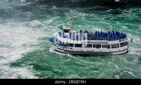 Cascate del Niagara, NY, USA - 13 giugno 2019: Nave con turisti si sposta alle cascate del Niagara, l'esperienza del tour in barca delle cascate è l'attrazione più antica del Nord America, e. Foto Stock