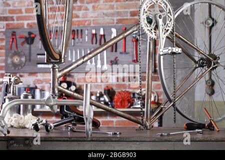 bicicletta d'epoca in officina su banco da lavoro con attrezzi, concetto fai da te Foto Stock