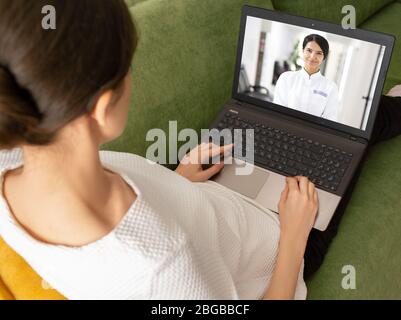 donna che ha consultato online il suo medico. il medico spiega i risultati dell'analisi al paziente tramite video chat. Resta a casa Foto Stock