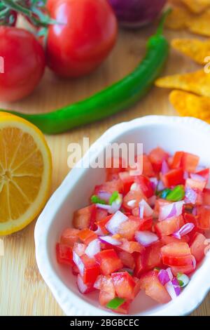 Salsa messicana Pico de gallo con pomodori, cipolle rosse, pepe jalapeno verde piccante, patatine di limone e mais nacho Foto Stock