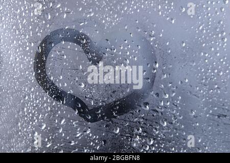 Primo piano del cuore disegnato sul finestrino bagnato Foto Stock
