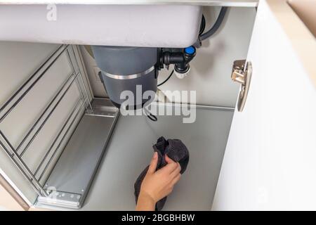 Perdita di smaltimento dei rifiuti sotto un lavandino, trinciatore rifiuti rotto Foto Stock