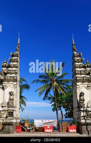 Kuta, Bali Island, Indonesia - 16 aprile 2020: Bandiera con segnale di avvertimento sul cancello d'ingresso alla spiaggia chiuso per impedire la diffusione di focolai di coronavirus. Foto Stock