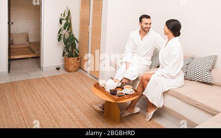 Una coppia molto bella seduta nella sala spa e bere un tè rilassante. Sala di sale, hammam e massaggi presso il centro benessere Foto Stock