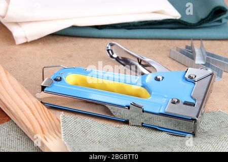 Cucitrice da costruzione con tessuto e punti metallici sul pannello di  sughero da vicino Foto stock - Alamy