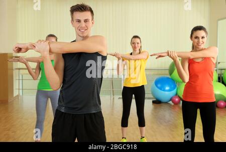 Giovani persone belle impegnati in palestra Foto Stock