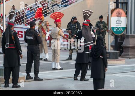 Soldati indiani e pakistani si stringono le mani alla cerimonia di frontiera di Wagah al confine tra Pakistan e India. Foto Stock