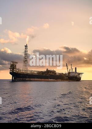 Stoccaggio e scarico in mare durante il tramonto della produzione galleggiante FPSO Foto Stock