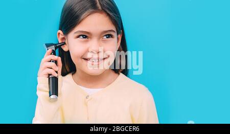 Ride ragazza mista con otoscopio. Esame di concetto dell'udito Foto Stock