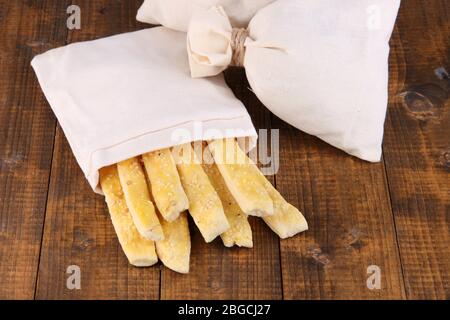 Bastoncini di pane in sacco su sfondo di legno Foto Stock