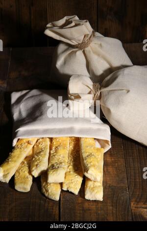 Bastoncini di pane in sacco su sfondo di legno Foto Stock