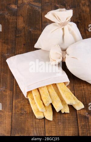 Bastoncini di pane in sacco su sfondo di legno Foto Stock