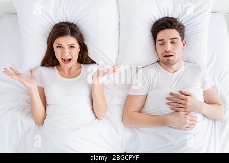 Alto angolo sopra la vista foto di signora pazzo russare marito ragazzo coppia sdraiati lenzuola coperta coperta coperta risveglio sgradevole non può dormire urlando soffrire Foto Stock