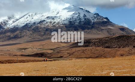 Scenario da viaggio a nord da Lhasa a Damshung, Tibet. Vicino al Monte Nyanchen Tangla, punto panoramico, 4640 m. di altitudine. Due donne sulla loro strada a casa Foto Stock