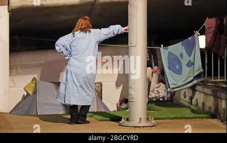 Città interna aiutare i senzatetto aiutare il volontario Avril darker controlli sul benessere di una giovane coppia senzatetto dormire ruvido sotto un ponte Luas nel quartiere finanziario di Dublino durante il blocco coronavirus. Foto Stock