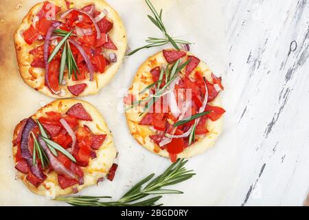 Pizze piccole su carta da forno primo piano Foto Stock