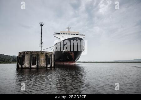 L'enorme nave traghetto Ro-Ro è ormeggiata nel porto sotto il cielo drammatico. Varna, Bulgaria Foto Stock