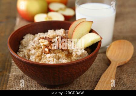 Gustosa farinata d'avena con noci e mele su tavola di legno Foto Stock