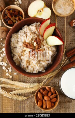 Gustosa farinata d'avena con noci e mele su tavola di legno Foto Stock