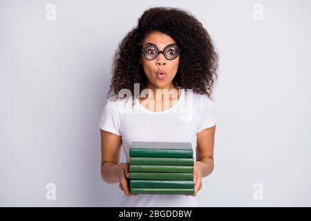 Ritratto primo piano di lei bella stupita sopraffatti ragazza wavy-capelli nerd indossare spesse specifiche tenuta in mani pila di materiali accademici isolati Foto Stock