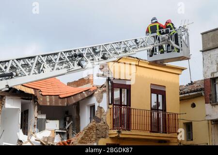 Vigili del fuoco su una gru di strada che lavora su un edificio crollato. Foto Stock