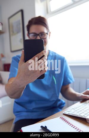 Telemedicine Concept, infermiere virtuale che usa il telefono cellulare felice e sorridente. Foto Stock