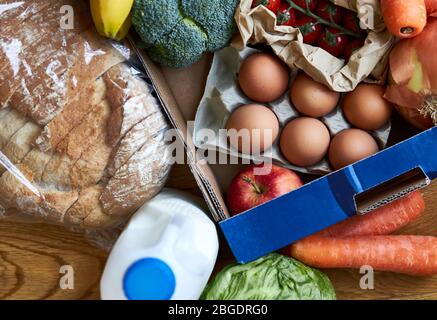 Consegna in scatola di mercato fresco piena di frutta e verdura prelevata dall'alto. Foto Stock