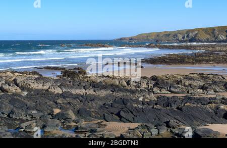 SUNNYSIDE BAY CULLEN MORAY FIRTH SCOTLAND SI SCAVA ATTRAVERSO LA SPIAGGIA DI SABBIA CON LA BASSA MAREA Foto Stock