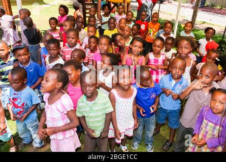 Soweto, Sudafrica - 16 novembre 2012: Giovani bambini di prescolare africani cantano canzoni nel parco giochi di una scuola di asilo Foto Stock