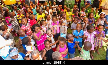 Soweto, Sudafrica - 16 novembre 2012: Giovani bambini di prescolare africani cantano canzoni nel parco giochi di una scuola di asilo Foto Stock