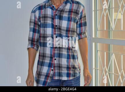 Uomo che indossa male buttoned e arrotolato maniche camicia a plaid, errore o intenzione di rompere la regola Foto Stock