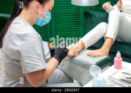 Donna che riceve la procedura di pedicure sui piedi nel salone termale. Foto Stock