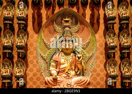 Singapore, ottobre 2019: Statua dorata del Buddha seduta in meditazione sul fiore di loto. All'interno del Tempio Reliquico del dente del Buddha, Chinatown Foto Stock