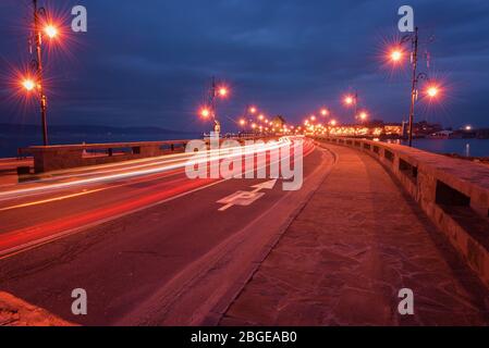 Vecchio mulino a vento nell'antica città di Nesebar in Bulgaria. L'ingresso alla città vecchia.UNESCO sito patrimonio mondiale. Luci per la circolazione su strada e la notte. Piste per auto leggere Foto Stock