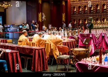 Singapore, 2019 ottobre: I monaci buddisti svolgono la cerimonia all'interno del Tempio Reliquico del dente del Buddha, Chinatown. La gente prega e rende omaggio al Buddha Foto Stock