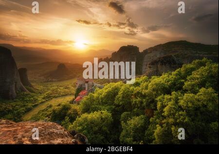 Monastero Meteora Grecia. Splendido paesaggio panoramico primaverile al tramonto. Vista sulle montagne e sulla foresta verde contro il cielo epico con le nuvole. UNESCO Foto Stock